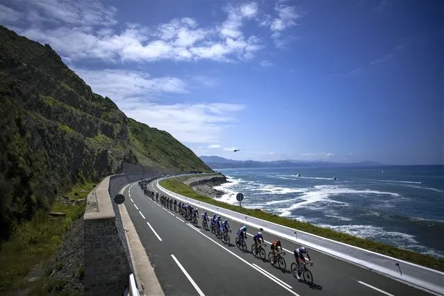The pack rides along the Bay of Biscay during the third stage of the Tour de France cycling race over 187.5 kilometers (116.5 miles) with start in Amorebieta Etxano, Spain and finish in Bayonne, France, Monday, July 3, 2023. (Photo by Daniel Cole/AP Photo)