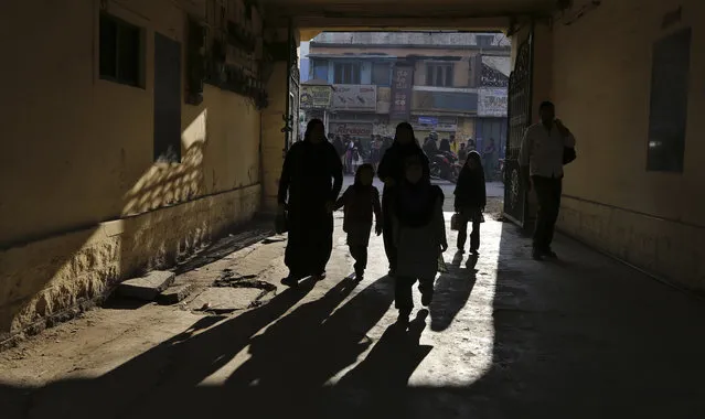 Indian children are silhouetted as they arrive with elders to attend their school in Bangalore, India, Wednesday, February 4, 2015. India's Right To Education Act promises free, compulsory schooling to all children ages 6 to 14, but millions of children still don't go to school and many who do are getting only the barest of educations. (Photo by Aijaz Rahi/AP Photo)