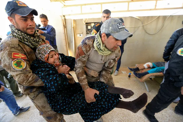 Iraqi security forces carry a displaced woman who was injured during clashes, while she flees from Islamic State militants of Tahrir neighborhood in Mosul, Iraq November 22, 2016. (Photo by Thaier Al-Sudani/Reuters)