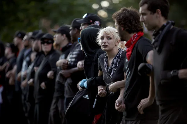 Protesters with a group known as “Antifa”, or anti-fascists, link arms at an event on the campus of the University of Virginia organized by the group Students Act Against White Supremacy marking the one year anniversary of a deadly clash between white supremacists and counter protesters August 11, 2018 in Charlottesville, Virginia. Charlottesville has been declared in a state of emergency by Virginia Gov. Ralph Northam as the city braces for the one year anniversary of the deadly clash between white supremacist forces and counter protesters over the potential removal of Confederate statues of Robert E. Lee and Stonewall Jackson. A “Unite the Right” rally featuring some of the same groups is planned for tomorrow in Washington, DC. (Photo by Win McNamee/Getty Images)