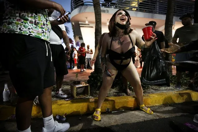 People enjoy spring break festivities ahead of an 8pm curfew imposed by local authorities, amid the coronavirus disease (COVID-19) pandemic, in Miami Beach, Florida, U.S., March 27, 2021. (Photo by Marco Bello/Reuters)
