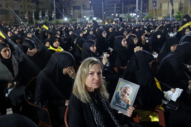 A Christian supporter of the Shiite movement Hezbollah holds a portrait of slain Iranian military commander Qasem Soleimani as she participates in a mourning ritual in the southern suburbs of Beirut on July 25, 2023, during the Muslim month of Muharram in the lead-up to Ashura. (Photo by Anwar Amro/AFP Photo)