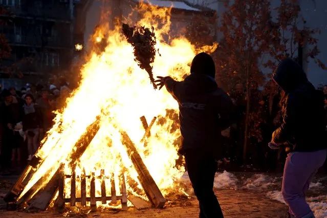 Believers burn dried oak branches, which symbolizes the Yule log, on Orthodox Christmas Eve in front of the St. Sava temple in Belgrade, Serbia, January 6, 2016. (Photo by Marko Djurica/Reuters)