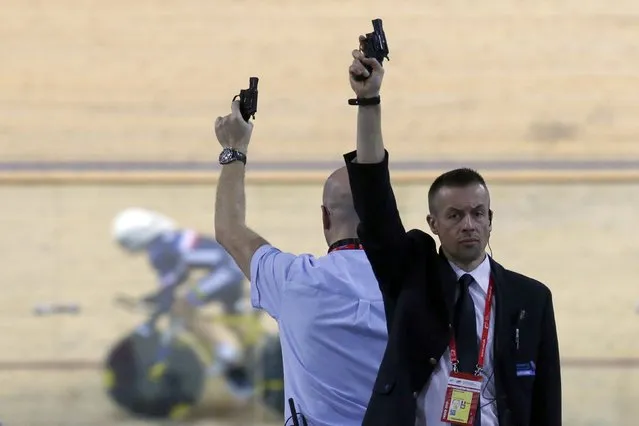Referees hold starting pistols during  the UCI Track Cycling World Cup at the velodrome of  Saint-Quentin-en-Yvelines, near Paris, February 20, 2015. (Photo by Charles Platiau/Reuters)