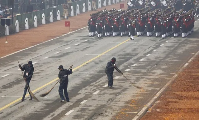 Sweepers clean the road as Indian soldiers march during the Republic Day parade in New Delhi, India, January 26, 2016. (Photo by Adnan Abidi/Reuters)