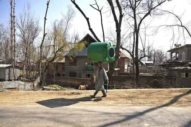 A Kashmiri village woman walks carrying an empty water tank on her head on World Water Day in Urwan, south of Srinagar, Indian controlled Kashmir, Sunday, March 22, 2015. (Photo by Mukhtar Khan/AP Photo)