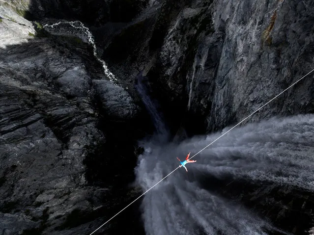 Lukas Irmler lying down on a line across Hunlen Falls. (Photo by Valentin Rapp/Caters News)