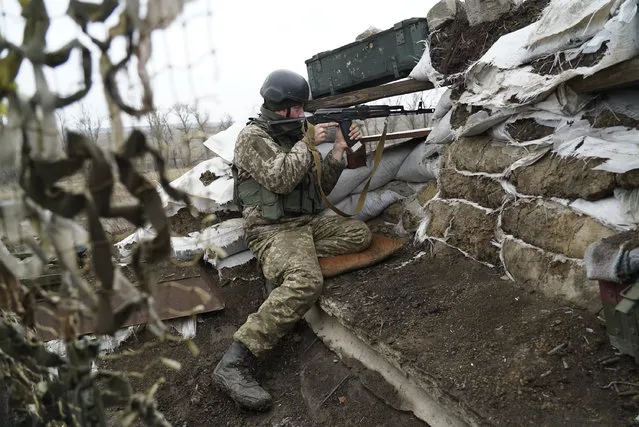 A Ukrainian soldier gets ready at position near the frontline with Russia-backed separatists in Shyrokyne, eastern Ukraine, Wednesday, November 28, 2018. Russia and Ukraine are still reeling from their first overt military confrontation since the 1991 collapse of the Soviet Union, a clash Sunday in the Kerch Strait near Russia-occupied Crimea where Russian border guards fired on three Ukrainian ships, seizing them and their 24 crewmembers. (Photo by Evgeniy Maloletka/AP Photo)