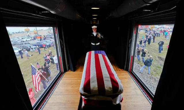 The flag-draped casket of former President George H.W. Bush passes through Magnolia, Texas, Thursday, Dec. 6, 2018, along the route from Spring to College Station, Texas. (Photo by David J. Phillip/Pool via Reuters)