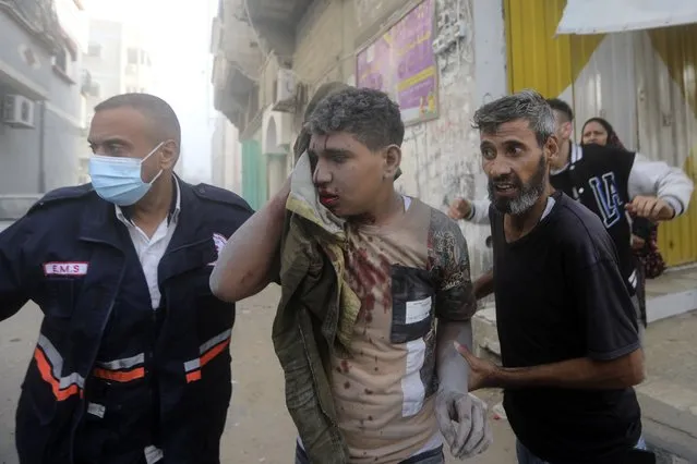 Palestinians evacuate a wounded youth following an Israeli airstrike in Khan Younis refugee camp, southern Gaza Strip, Tuesday, November 7, 2023. (Photo by Mohammed Dahman/AP Photo)