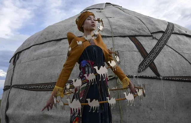 A model displays an outfit from the collection by Kyrgyzstan's designer Cholponay Almaz Kyzy during the World Nomads Fashion festival Issyk-Kul 2021, at Cholpon-Ata, a resort town on the northern shore of Lake Issyk-Kul, 207 kilometers (129 miles) east of Bishkek, Kyrgyzstan, Saturday, July 17, 2021. (Photo by Vladimir Voronin/AP Photo)
