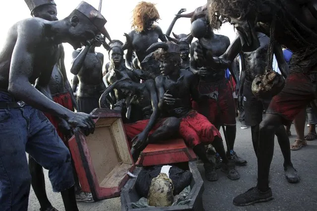 Revellers sit on a fake coffin containing a human skull as they take part in the Carnival 2016 parade in Port-au-Prince, Haiti, February 9, 2016. (Photo by Andres Martinez Casares/Reuters)