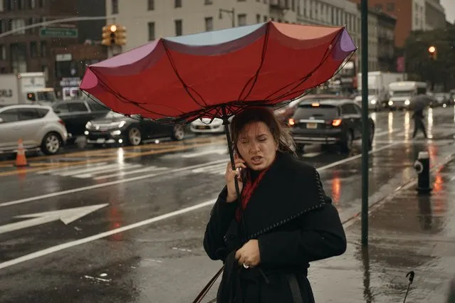 A woman holds her umbrella as she speaks on the phone on Friday, September 29, 2023 in Brooklyn borough of New York. A potent rush-hour rainstorm swamped the New York metropolitan area on Friday, shutting down some subways and commuter railroads, flooding streets and highways, and delaying flights into LaGuardia Airport. (Photo by Andres Kudacki/AP Photo)