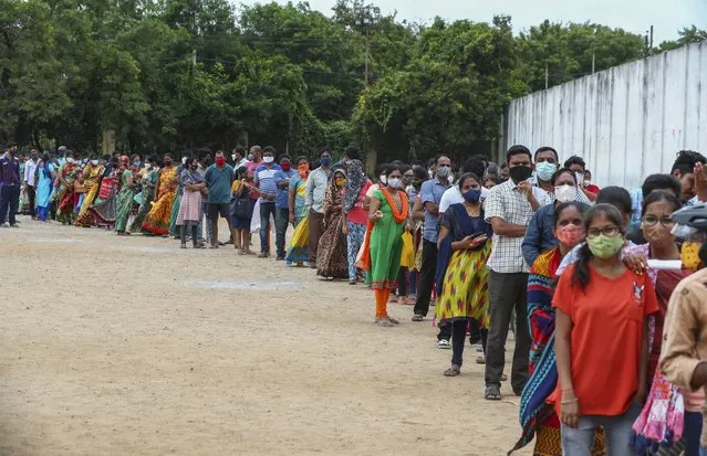 Hundreds of people line up to receive their second dose of vaccine against the coronavirus at the municipal ground in Hyderabad, India, Thursday, July 29, 2021. (Photo by Mahesh Kumar A./AP Photo)