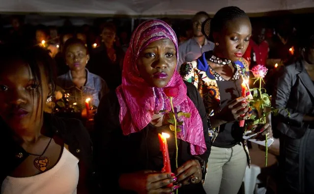 Kenyans hold candles and flowers as they listen to the names of each of the victims of the Garissa attack being read out aloud, during a vigil at Uhuru Park in Nairobi, Kenya Tuesday, April 7, 2015. (Photo by Ben Curtis/AP Photo)