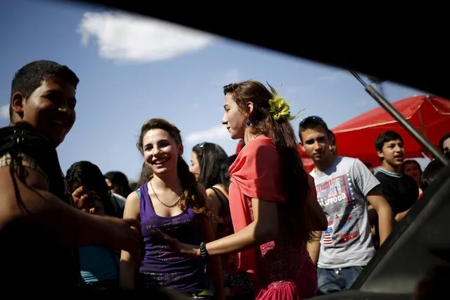 Bulgarian Roma people from the close-knit Kalaidjii clan dance during a so-called “bride fair” in a suburb of the city of Plovdiv April 13, 2015. Each year Roma families from the close-knit Kalaidjii clan gather during what they call a “bride fair”, an event offering parents a chance to meet and to arrange marriages for their children. (Photo by Stoyan Nenov/Reuters)