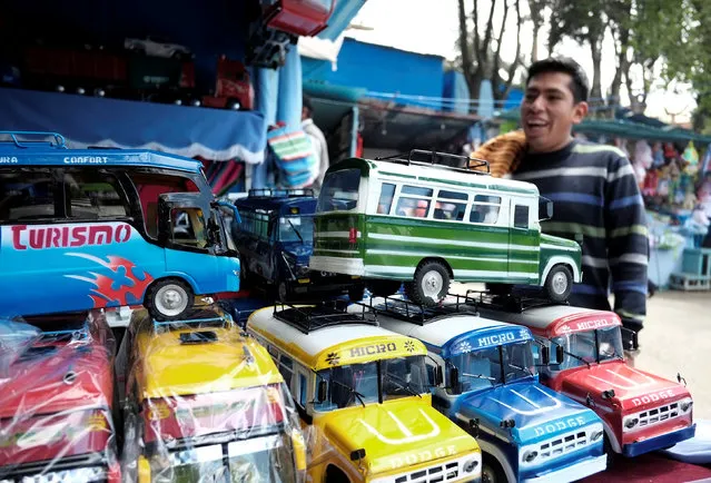 A man looks at miniature vehicles during the “Alasitas” fair, where people buy miniature versions of goods they hope to acquire in real life, in La Paz, Bolivia, January 24, 2017. (Photo by David Mercado/Reuters)