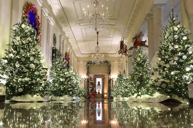 The Cross Hall between the East Room and the State Dining Room is lined with frosted Christmas tress during a media preview of the 2023 holiday decorations at the White House November 27, 2023 in Washington, DC. The theme for this year's White House decorations is “Magic, Wonder and Joy”, and is designed to capture the “delight and imagination of childhood”. The White House expects to welcome approximately 100,000 visitors during the holiday season. (Photo by Kevin Dietsch/Getty Images)