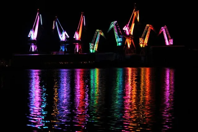 The cranes of Uljanik shipyard are painted with light during Visualia Festival in the Adriatic town of Pula May 4, 2014. Visualia Festival 2014 is a festival of audio-visual art with the objective of modernizing and approaching new technologies to citizens. The second edition of the festival will offer light exhibitions, 3D video mapping on historic buildings of the city, two light performances and light installations. (Photo by Antonio Bronic/Reuters)