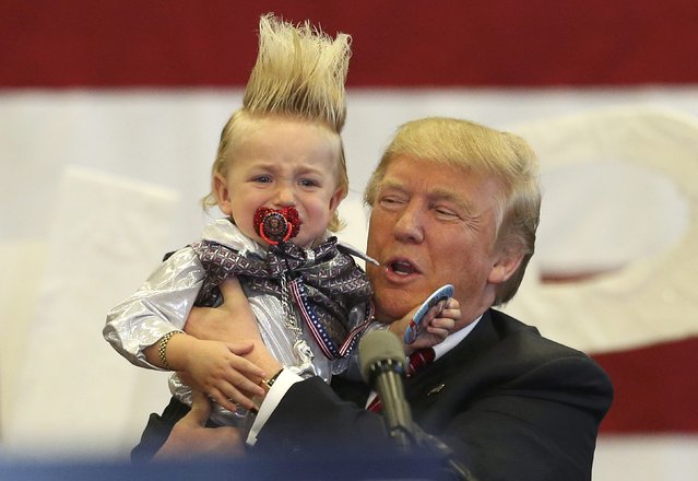 Republican U.S. presidential candidate Donald Trump holds up a crying young child from the crowd as he arrives at a Trump campaign rally in New Orleans, Louisiana March 4, 2016. (Photo by Layne Murdoch Jr./Reuters)