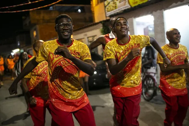Men dance during a rehearsal by the Unidos de Padre Miguel samba school in Rio de Janeiro, Brazil, Tuesday, September 28, 2021. The Unidos de Padre Miguel samba school is already preparing for next year's carnival, rehearsing with some members without public participation. (Photo by Bruna Prado/AP Photo)