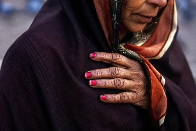 An Indian pilgrim holds her scarf as she embarks on a visit to the sacred Pashupatinath temple in Kathmandu, Nepal, January 12, 2024. The centuries-old temple is one of the most important pilgrimage sites in Asia for Hindus. Nepal and India are the world's two Hindu-majority nations and share a strong religious affinity. Every year, millions of Nepalese and Indians visit Hindu shrines in both countries to pray for success and the well-being of their loved ones. (Photo by Niranjan Shrestha/AP Photo)