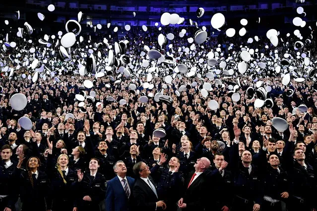 Two thousand three hundred police officers throw their caps in the air after they took their oath of allegiance to the state constitution in the Lanxess Arena in Cologne, Germany, 03 April 2019. The young policemen and policewomen were hired on 01 September 2018 and completed the first phase of their training. (Photo by Sascha Steinbach/EPA/EFE)
