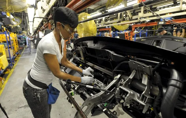 Auto worker Betty Smith assembles a dashboard at Ford's Kansas City Assembly Plant where new aluminum intensive Ford F-Series pickup is built in Claycomo, Missouri May 5, 2015. (Photo by Dave Kaup/Reuters)