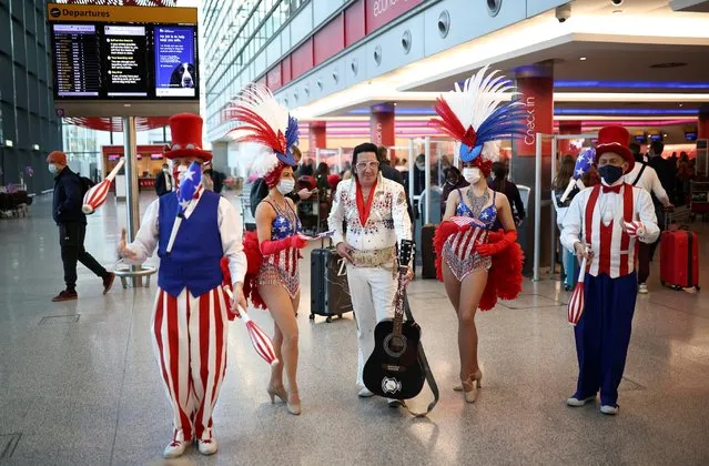 Performers engage with travellers as they queue to check into Virgin Atlantic and Delta Air Lines flights at Heathrow Airport Terminal 3, following the lifting of restrictions on the entry of non-U.S. citizens to the United States imposed to curb the spread of the coronavirus disease (COVID-19), in London, Britain, November 8, 2021. (Photo by Henry Nicholls/Reuters)