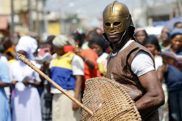 A man dressed up as a soldier takes part in a re-enactment of the crucifixion of Jesus Christ on Good Friday along a road near St. Leo's Catholic church in Lagos, Nigeria, March 25, 2016. (Photo by Akintunde Akinleye/Reuters)