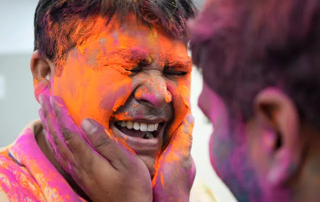 Government employees apply colors on each others' face before leaving for holidays to celebrate Holi, the festival of colors, in Lucknow, Saturday, March 23, 2024. The festival will be observed on March 8, but the festivities start almost a week in advance. (Photo by Rajesh Kumar Singh/AP Photo)