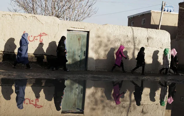 Afghan women walk near still water in Kabul, Afghanistan, Thursday, December 12, 2013. Heavy rain flooded some streets in Kabul due to poorly designed sewage facilities. (Photo by Rahmat Gul/AP Photo)