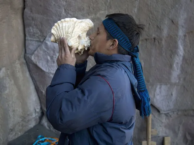 A villagers blows on a conch shell during a ceremony on a rock formation on the slopes of the Popocatepetl volcano. (Photo by Eduardo Verdugo/AP Photo)