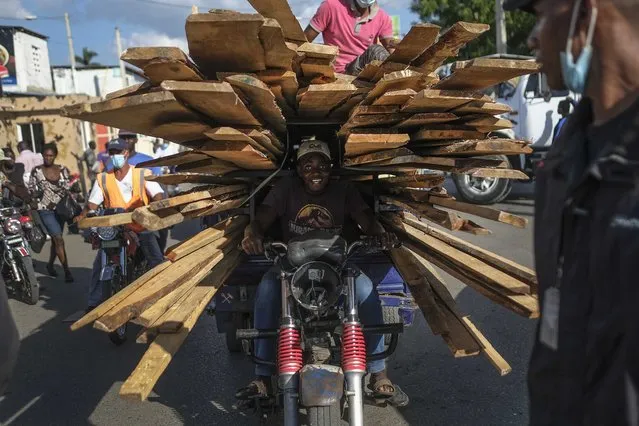 A man returns to Haiti after buying pieces of wood at a market in the border town of Dajabon, Dominican Republic, Friday, November 19, 2021. (Photo by Matias Delacroix/AP Photo)