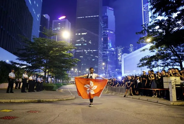 A protester holds a flag of Hong Kong as he attends a demonstration demanding Hong Kong's leaders to step down and withdraw the extradition bill, outside Office of the Chief Executive in Hong Kong, China, June 16, 2019. (Photo by Thomas Peter/Reuters)