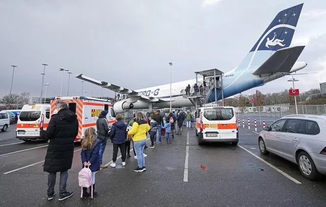 Families line up in front of an Airbus A300 Zero G plane, where children between 5 and 11 years get a vaccination against the coronavirus at the airport in Cologne, Germany, Sunday, January 9, 2022. The vaccination center inside the out of operation aircraft for parabolic flights is to promote COVID-19 vaccinations as an exciting event for the kids. (Photo by Martin Meissner/AP Photo)