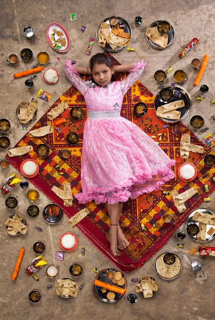 Anchal Sahani, 10, Chembur, Mumbai, India, 2017: Anchal lives in an 2.4 metre x 2.4 metre aluminium shack on a construction site in a suburb of Mumbai with her parents and two siblings. Although her father makes less than $5 a day, it’s just enough for her mother to buy fresh vegetables, such as okra and cauliflower, and make homemade curry, lentils and roti from scratch. (Photo by Gregg Segal/The Guardian)