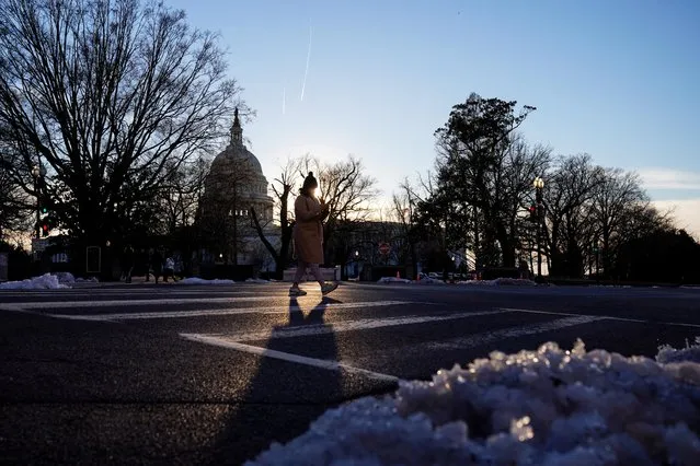 A woman crosses the street at sunset on Capitol Hill in Washington, U.S., January 11, 2022. (Photo by Sarah Silbiger/Reuters)