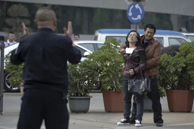 A police officer speaks to a man holding a woman hostage with a cleaver on a street in Kunming, Yunnan province April 8, 2014. Police successfully rescued the hostage and detained the man after a one-hour standoff. The reason of the crime remains unclear, local media reported. (Photo by Reuters)