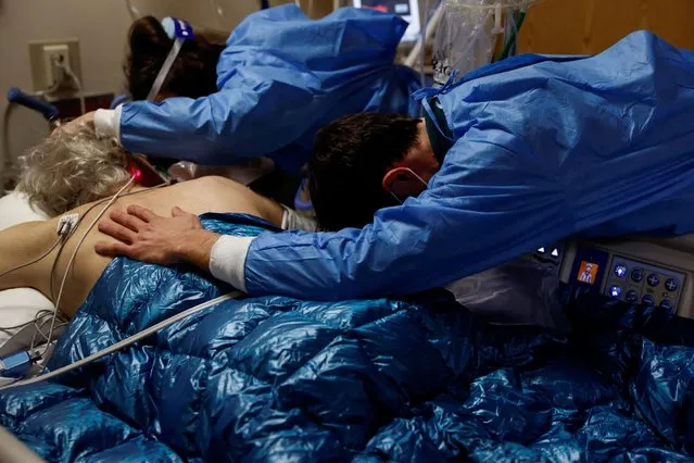 A son and daughter embrace their father, a coronavirus disease (COVID-19) patient in the Intensive Care Unit (ICU) ward, before his intubation procedure at the Providence Mission Hospital in Mission Viejo, California, U.S., January 25, 2022. (Photo by Shannon Stapleton/Reuters)