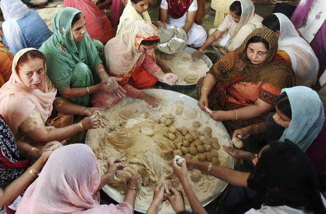 Devotees make chapattis (bread) at a community kitchen in a Gurdwara (Sikh temple) on Baisakhi festival in Chandigarh April 14, 2011. (Photo by Ajay Verma/Reuters)