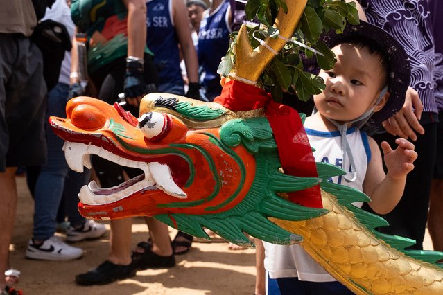A child looks at a dragon's head in the annual dragon boat race to celebrate the Tuen Ng festival in Hong Kong, Monday, June 10, 2024. (Photo by Chan Long Hei/AP Photo)
