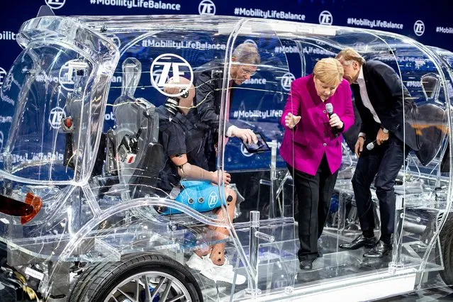 German Chancellor Angela Merkel climbs out of a transparent car with security devices during her visit to the IAA Auto Show in Frankfurt, Germany, Thursday, September 12, 2019. (Photo by Michael Probst/AP Photo)