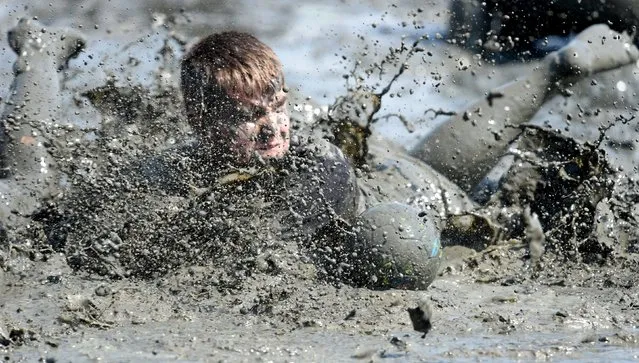 Participants fight for the ball during a handball match at the so called “Wattoluempiade” (Mud Olympics) in Brunsbuettel at the North Sea, July 11, 2015. (Photo by Fabian Bimmer/Reuters)