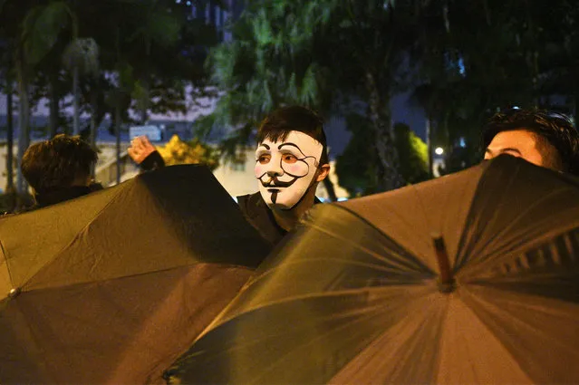 A protester wearing a mask takes part in a protest in the Wanchai district in Hong Kong on October 4, 2019, after people hit the streets when the government earlier announced a ban on facemasks. Hong Kong's leader on October 4 invoked a rarely used colonial-era emergency law to ban people from wearing face masks in a bid to put an end to months of violent protests. (Photo by Philip Fong/AFP Photo)