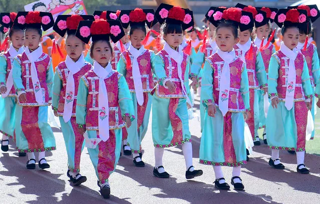 Primary school students wearing traditional Chinese costumes walk during a sports event in Shenyang, Liaoning province, China, April 27, 2017. (Photo by Reuters/Stringer)