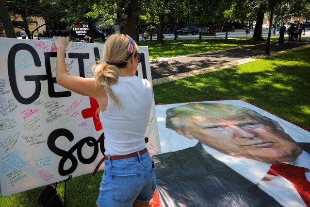 A woman writes a get well message to former President Donald Trump during a prayer vigil hosted by Turning Point Action near the venue for the Republican National Convention (RNC), at Zeidler Union Square in Milwaukee, Wisconsin on July 14, 2024. (Photo by Andrew Kelly/Reuters)