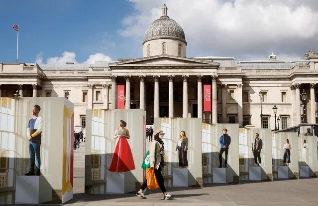 A woman walks past an exhibition of photography in Trafalgar Square in London, Britain, April 1, 2022. (Photo by John Sibley/Reuters)