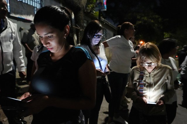 Supporters of Venezuelan opposition presidential candidate Edmundo Gonzalez search for news about the election results during Venezuela's presidential election, in Caracas, Venezuela on July 28, 2024. (Photo by Alexandre Meneghini/Reuters)