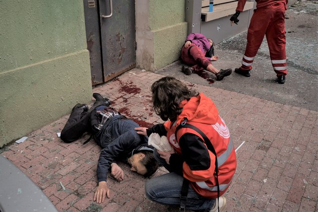 Emergency workers help injured civilians during a Russian bombardment in Kharkiv, Ukraine, Sunday, April 17, 2022. (Photo by Felipe Dana/AP Photo)